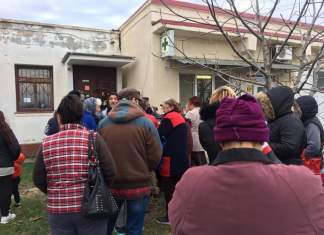 Zeci de oameni adunați la sediul Poștei Române din Remetea Mare